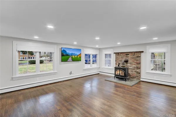 an empty room with wooden floor and fireplace