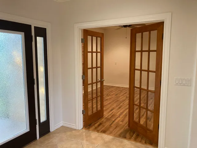 a view of a hallway with wooden floor and dining room