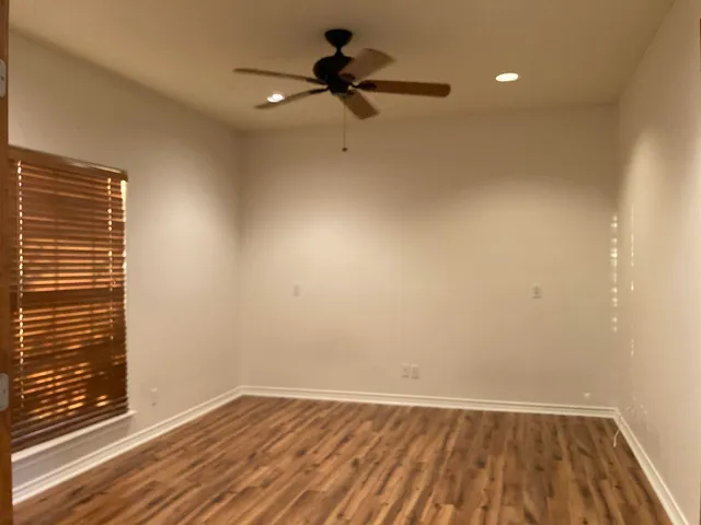 a view of a room with wooden floor and a ceiling fan