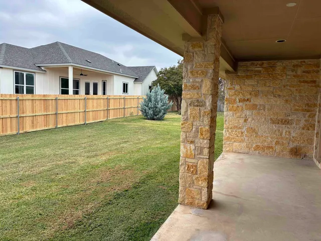 a view of a house with a yard and sitting area