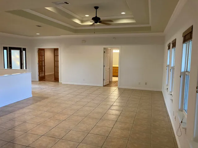 an empty room with fan and windows
