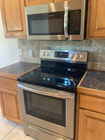 a stove top oven sitting inside of a kitchen