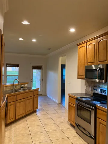 a kitchen with stainless steel appliances a sink stove and cabinets