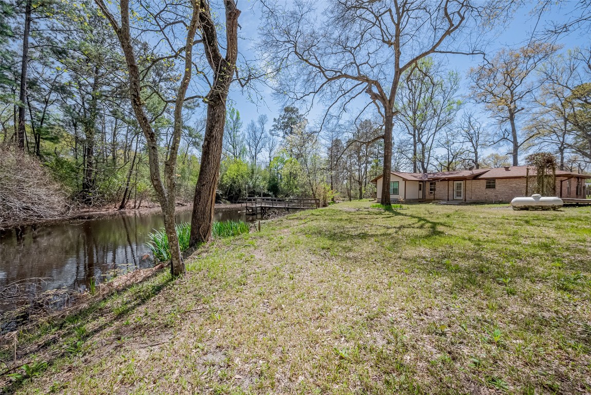 14 Veronica Lane Huntsville, TX 77340 - Photo 44 of 50 a backyard of a house with lots of green space and fountain