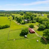 an aerial view of ocean and residential houses with outdoor space