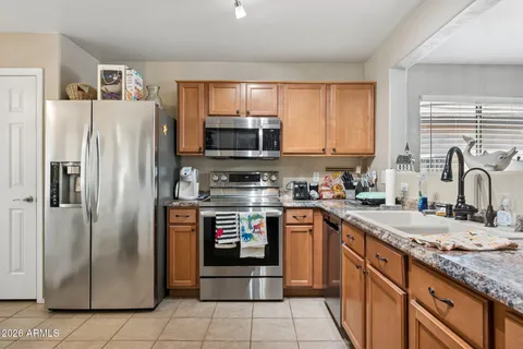 a kitchen with stainless steel appliances granite countertop a refrigerator stove and sink