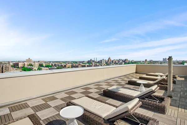 a view of a terrace with furniture and city view