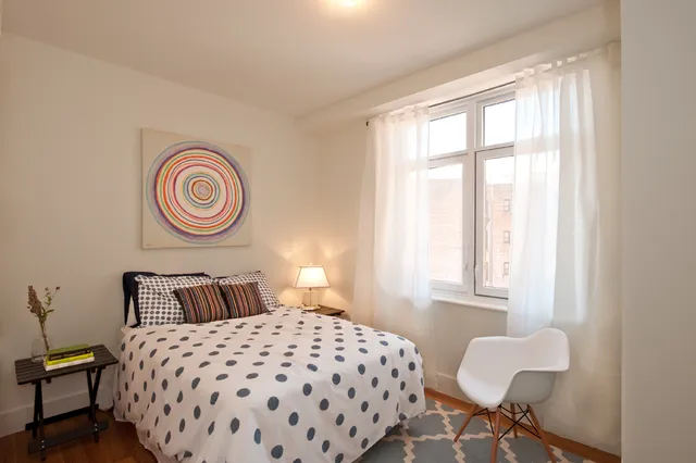 a bedroom with a bed and a lamp