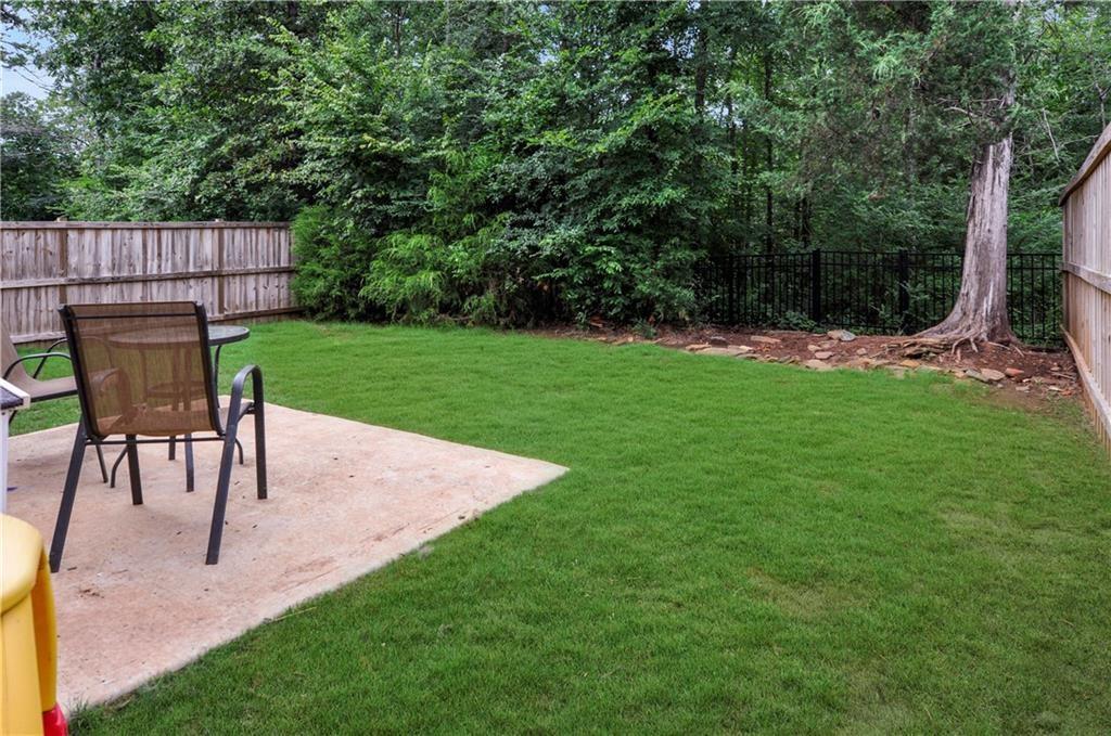 1929 Charcoal Ives Road Lawrenceville, GA 30045 - Photo 14 of 14 a view of a backyard with table and chairs potted plants and wooden fence