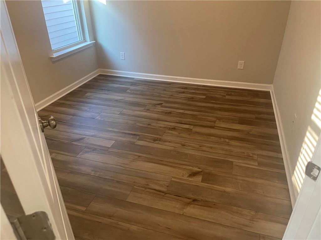 1929 Charcoal Ives Road Lawrenceville, GA 30045 - Photo 9 of 14 a view of an empty room with wooden floor and a window