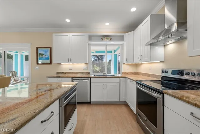 a kitchen with kitchen island granite countertop a sink stainless steel appliances and cabinets