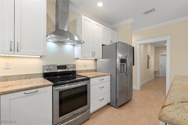 a kitchen with stainless steel appliances a stove a refrigerator and a cabinets