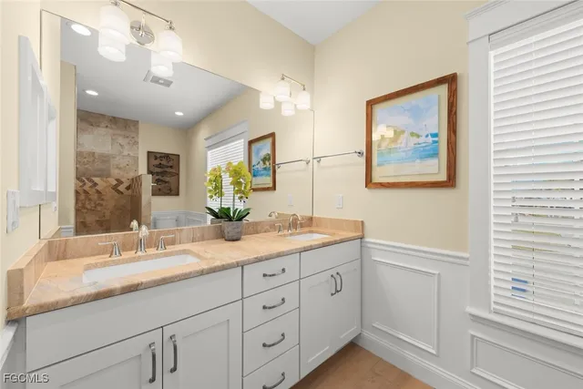 a bathroom with a granite countertop sink a large mirror a vanity and window