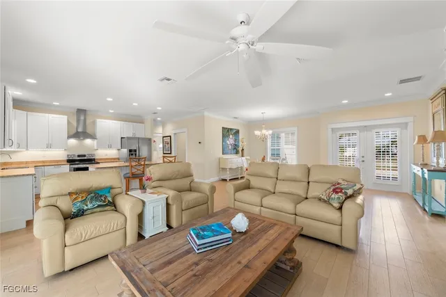 a living room with furniture kitchen view and a wooden floor