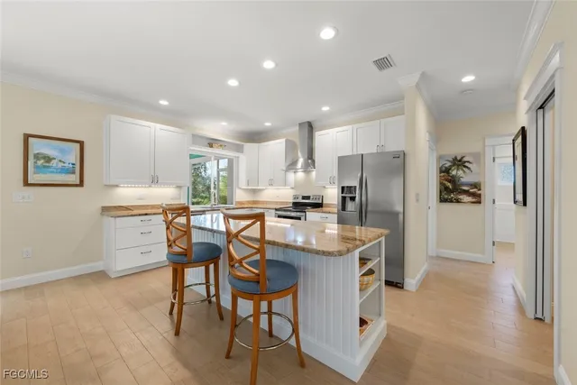 a kitchen with a refrigerator a sink and chairs