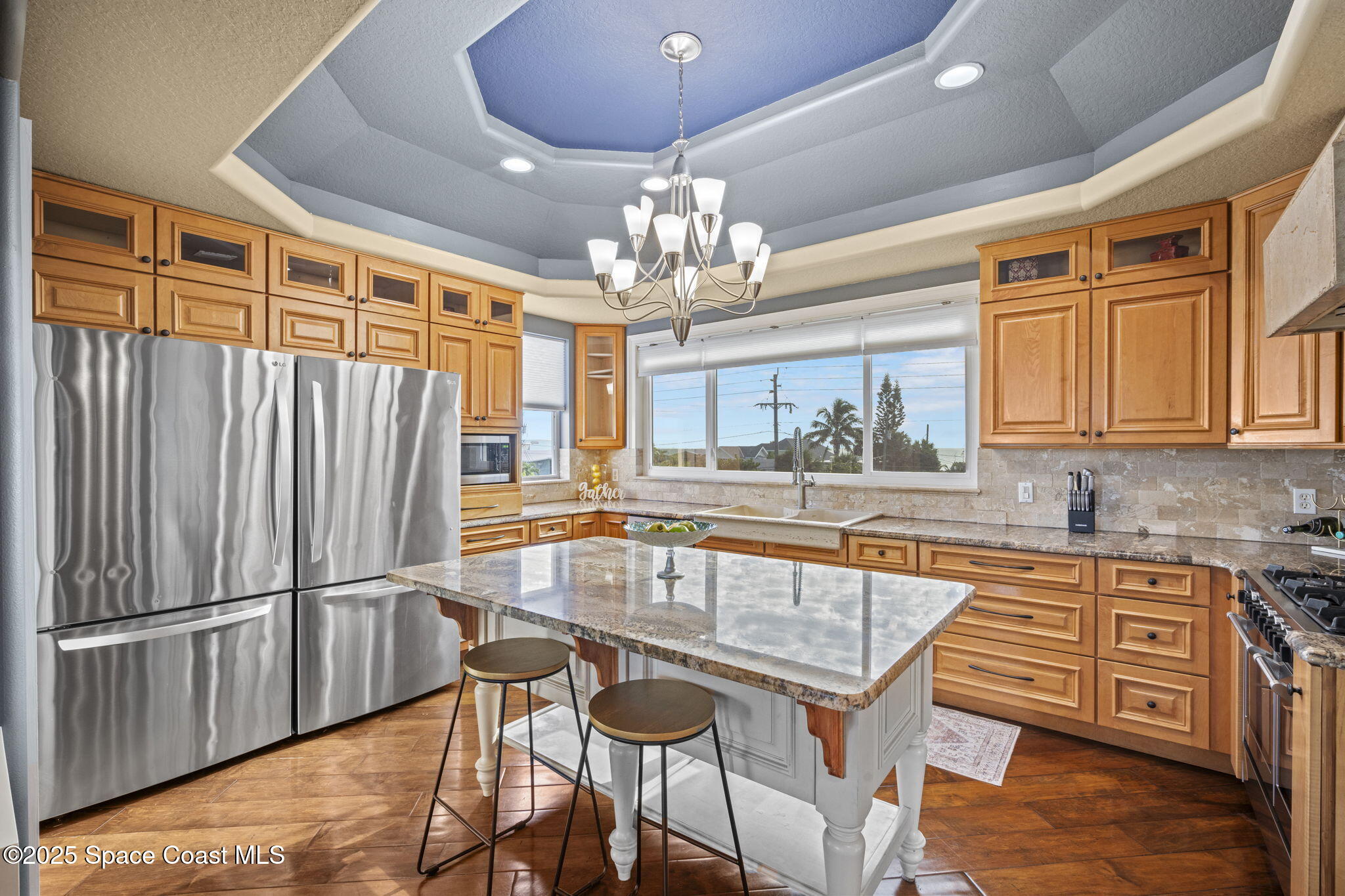 2694 South Atlantic Avenue Cocoa Beach, FL 32931 - Photo 11 of 72 a kitchen with granite countertop a refrigerator a sink dishwasher a dining table and chairs with wooden floor