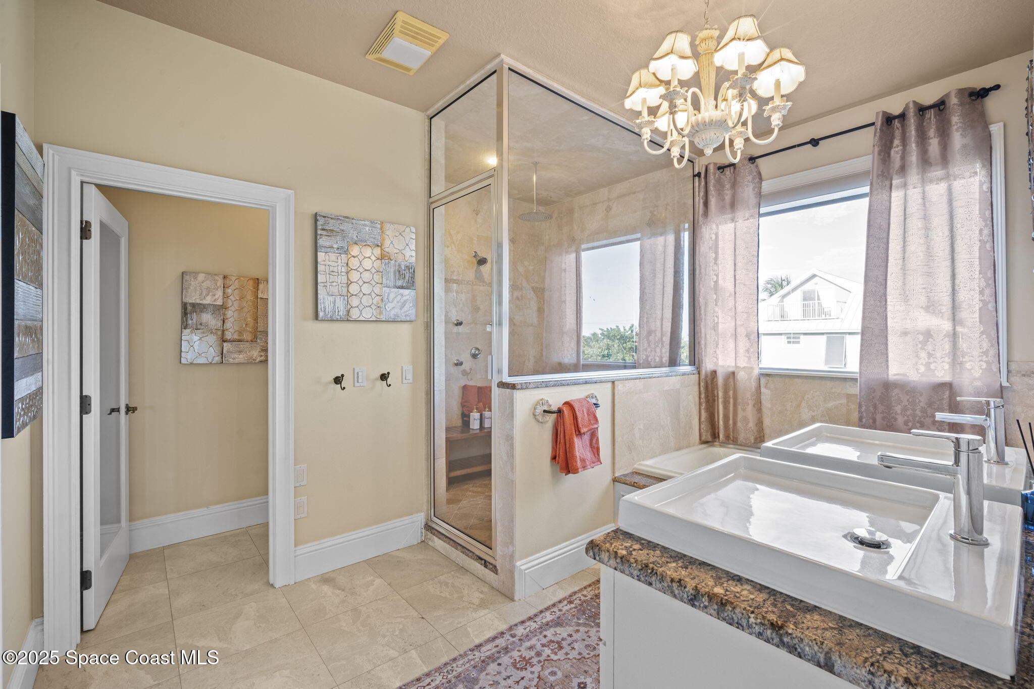 2694 South Atlantic Avenue Cocoa Beach, FL 32931 - Photo 30 of 72 a spacious bathroom with a granite countertop sink a large mirror and a bathtub with shower