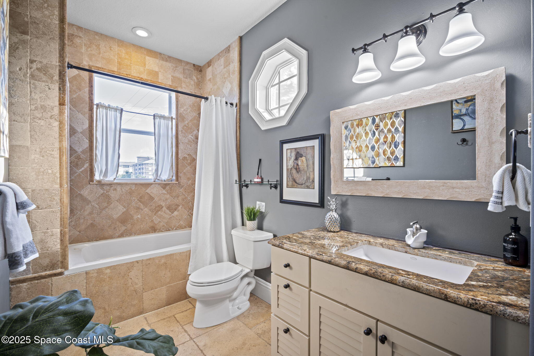 2694 South Atlantic Avenue Cocoa Beach, FL 32931 - Photo 35 of 72 a spacious bathroom with a granite countertop toilet a sink and a bathtub