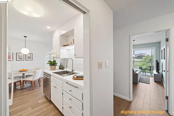 a kitchen that has a lot of cabinets a sink and wooden floor