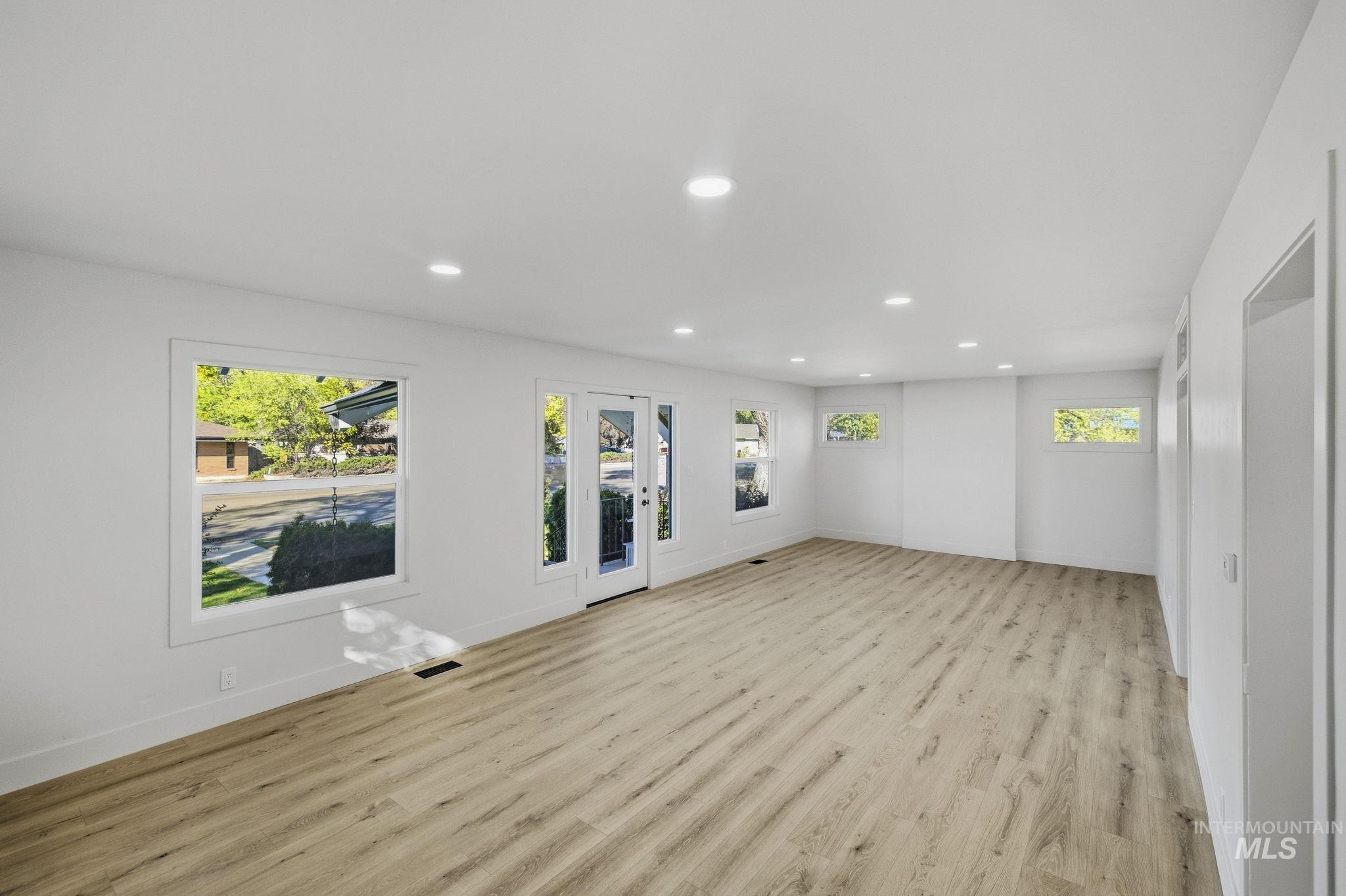 3113 West Overland Road Boise, ID 83705 - Photo 22 of 40 Recessed lighting throughout, wood-finish flooring, multiple windows, and a glass-paneled exterior door