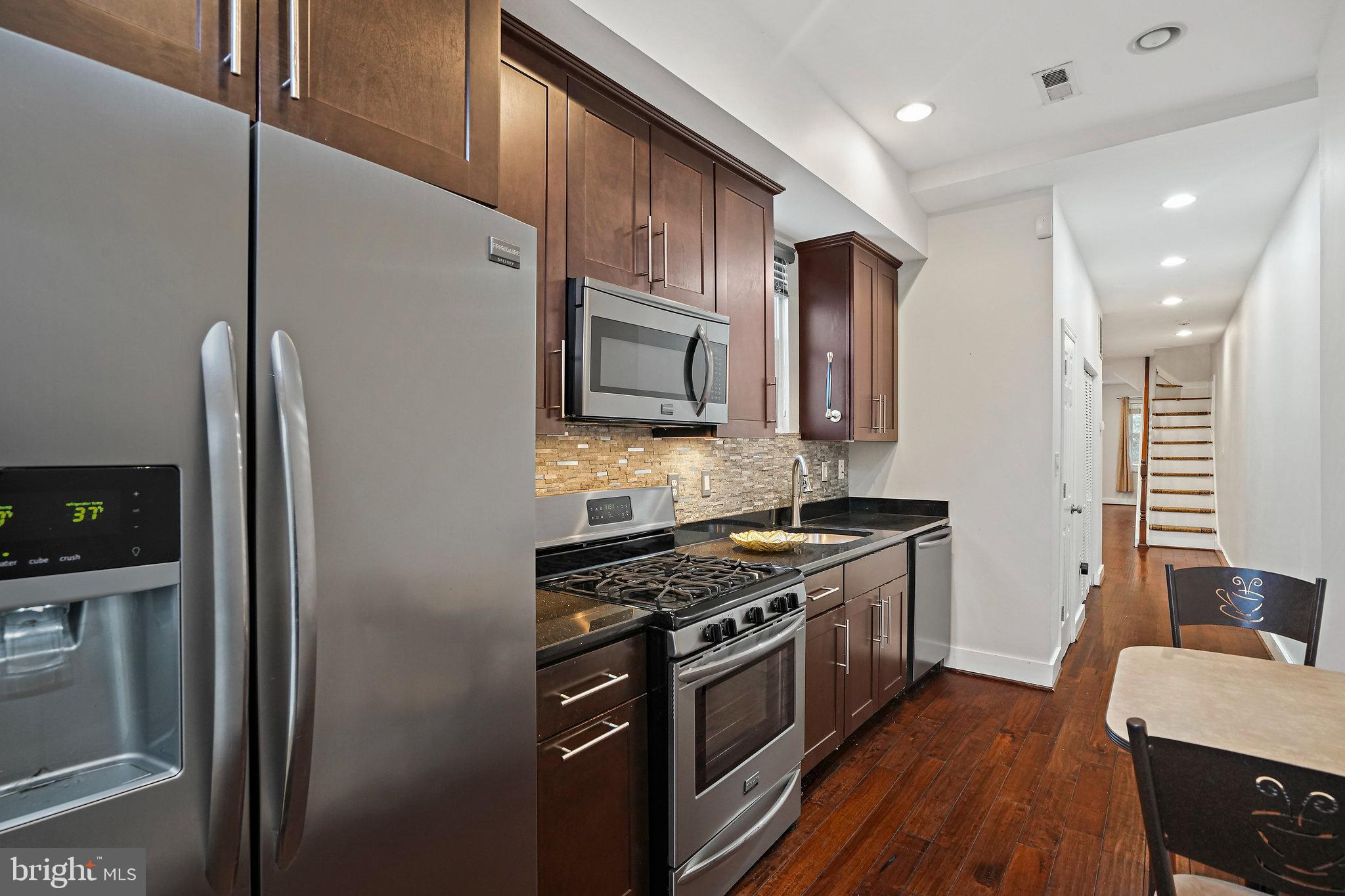 2012 2nd Street Northwest Washington, DC 20001 - Photo 3 of 9 a kitchen with stainless steel appliances granite countertop a stove refrigerator and microwave