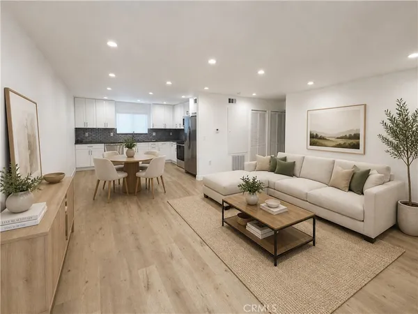 a living room with furniture and a dining table with kitchen view