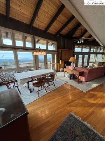 a living room with furniture pool table and large windows