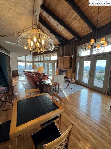 a view of a dining room with furniture a chandelier and wooden floor