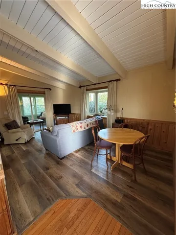 a living room with furniture a table and chairs next to a window