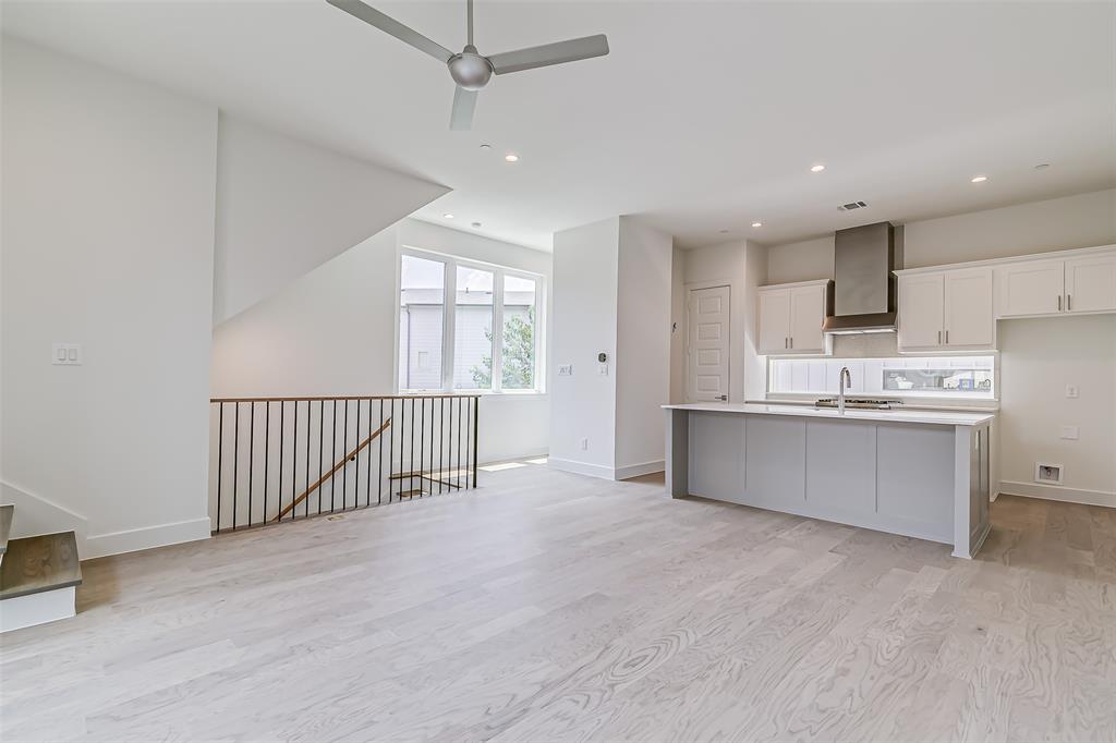 6028 Lewis Street, Unit 202 Dallas, TX 75206 - Photo 18 of 37 a large white kitchen with wooden floors and white walls
