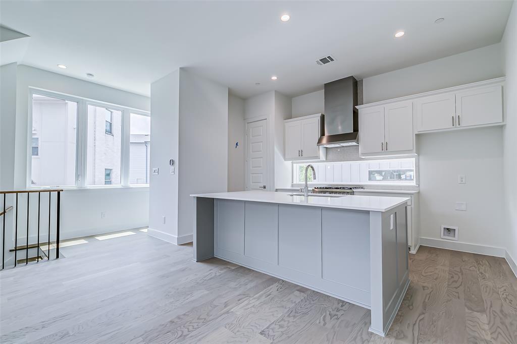 6028 Lewis Street, Unit 202 Dallas, TX 75206 - Photo 20 of 37 a kitchen with kitchen island granite countertop a sink cabinets and stainless steel appliances