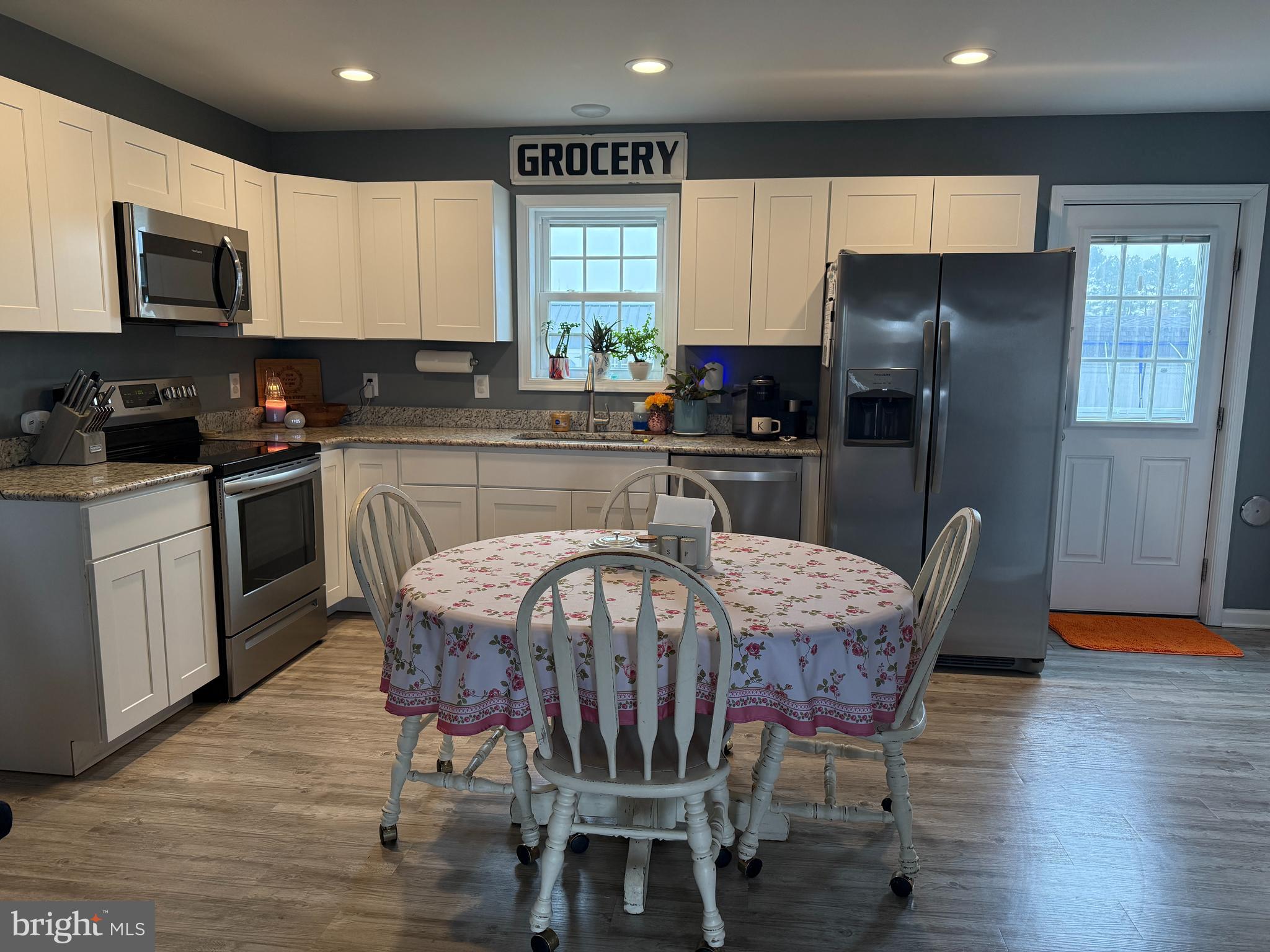 113 State Street Sharptown, MD 21861 - Photo 4 of 18 a kitchen with stainless steel appliances granite countertop a stove a refrigerator a kitchen island and chairs