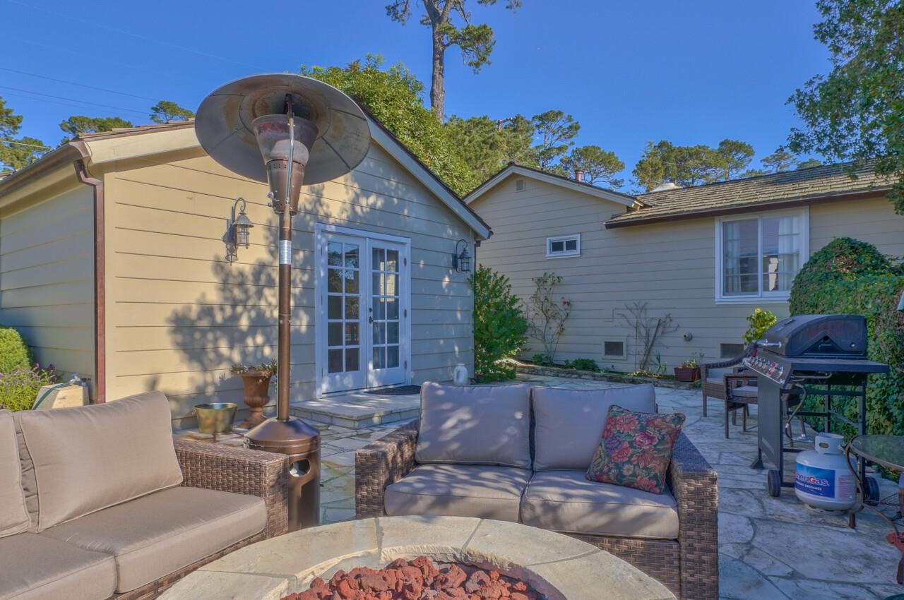 24770 Valley Way Carmel, CA 93923 - Photo 31 of 39 a view of a patio with couches table and chairs under an umbrella with a fire pit