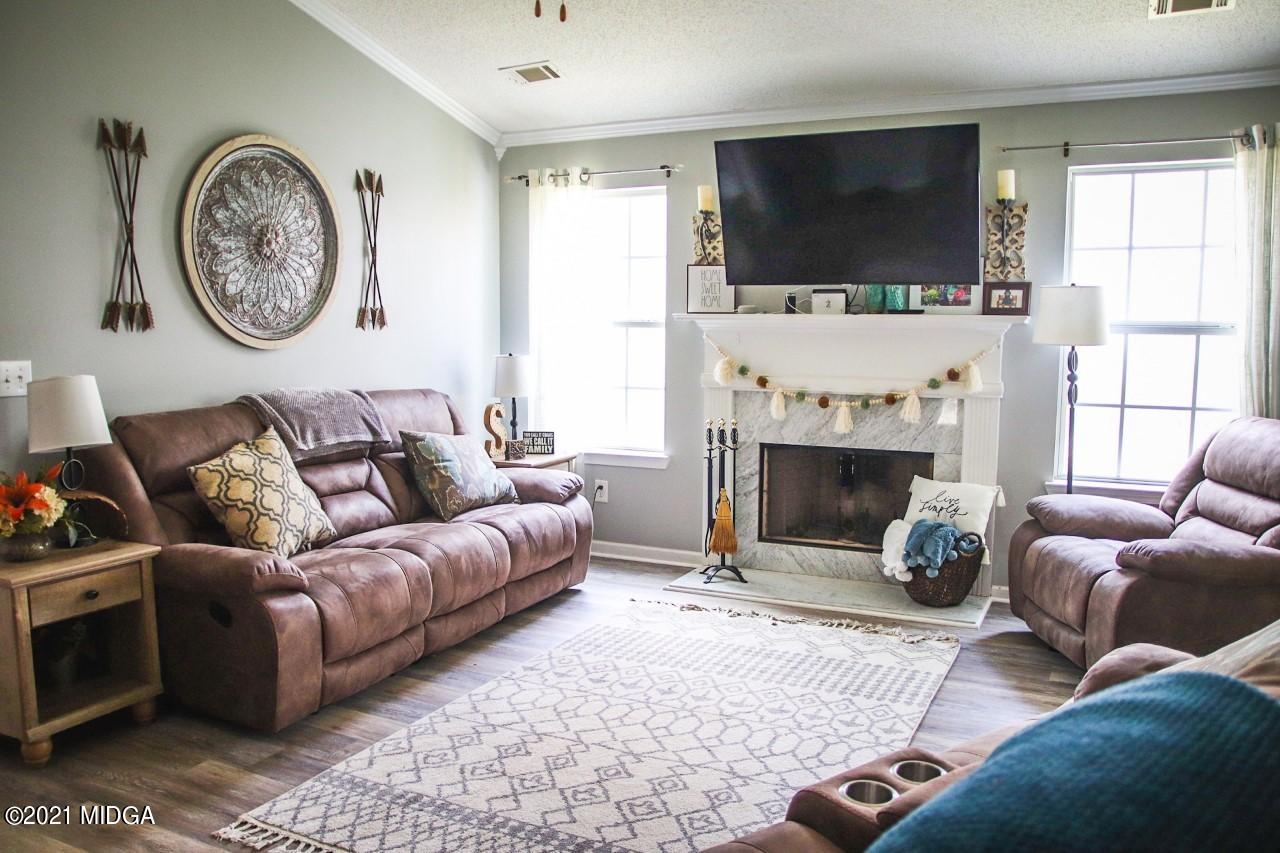 3369 Trotters Ridge Trail Gray, GA 31032 - Photo 3 of 13 a living room with furniture a flat screen tv and a fireplace