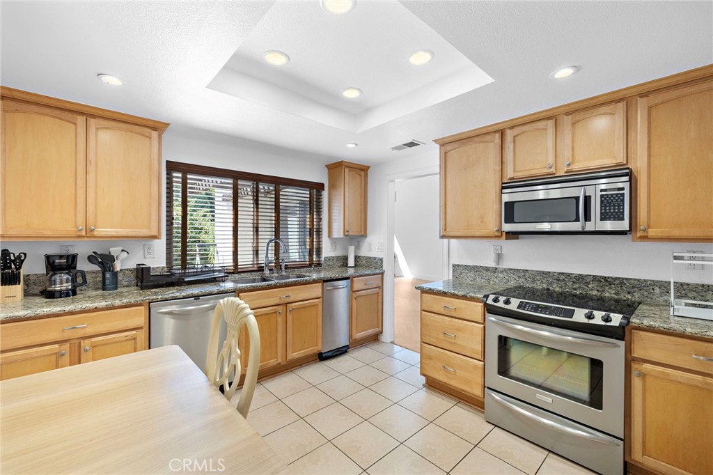 18 Navarre, Unit 133 Irvine, CA 92612 - Photo 10 of 32 a kitchen with stainless steel appliances granite countertop a stove a sink and a microwave
