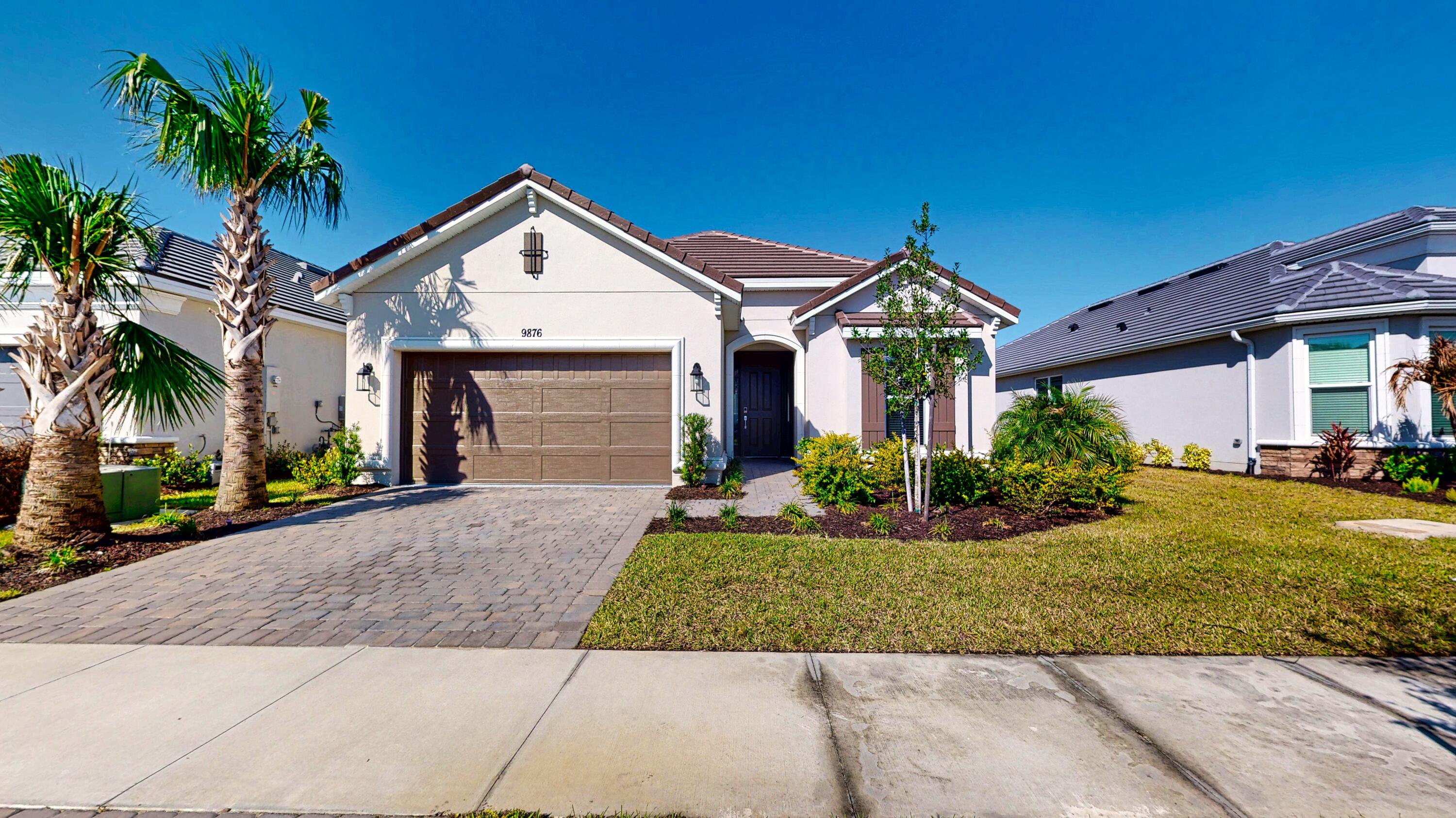 9876 Santini Road Port St. Lucie, FL 34987 - Photo 2 of 45 a front view of a house with a yard and garage
