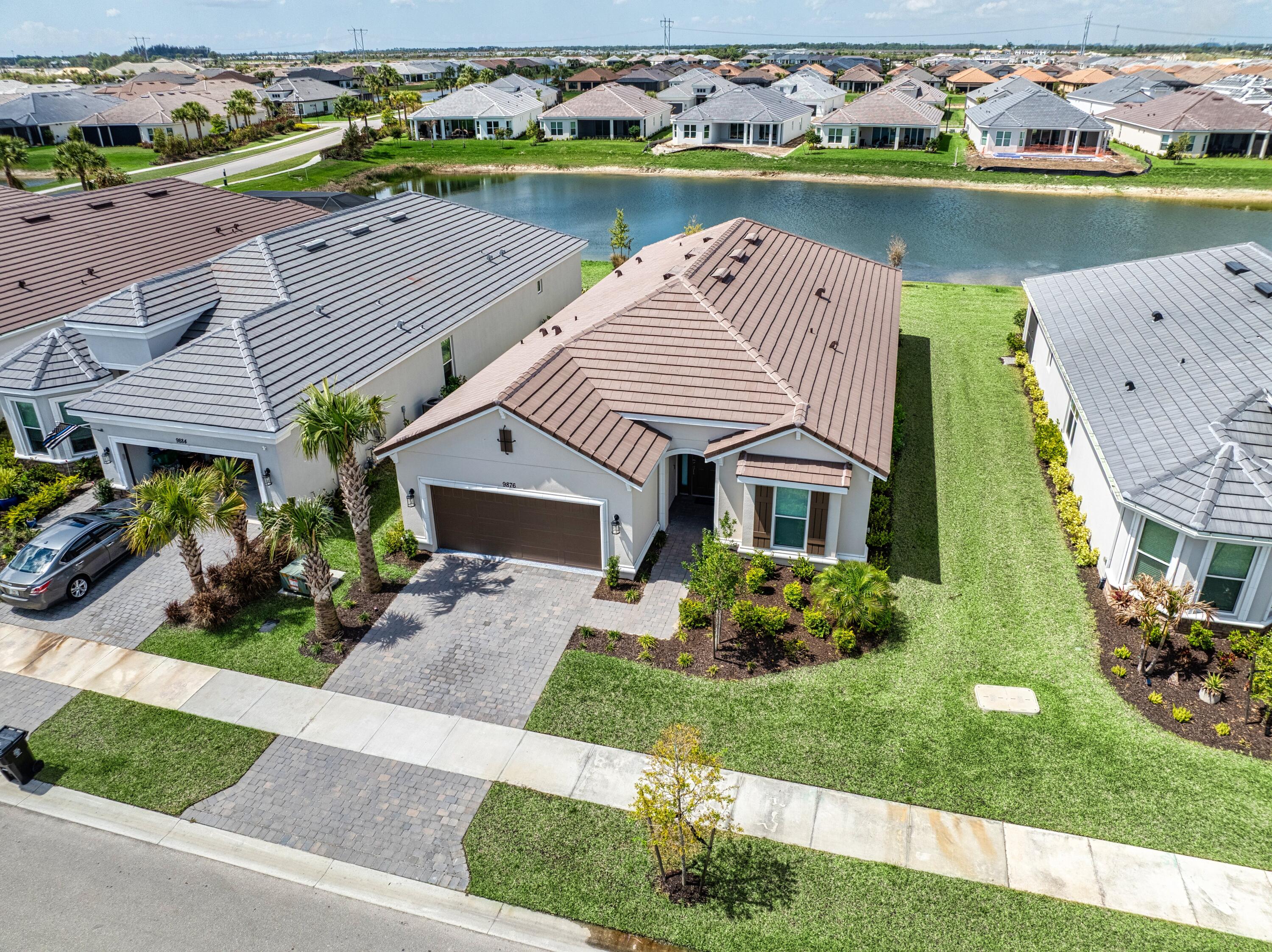 9876 Santini Road Port St. Lucie, FL 34987 - Photo 25 of 45 an aerial view of a house with a garden and lake view