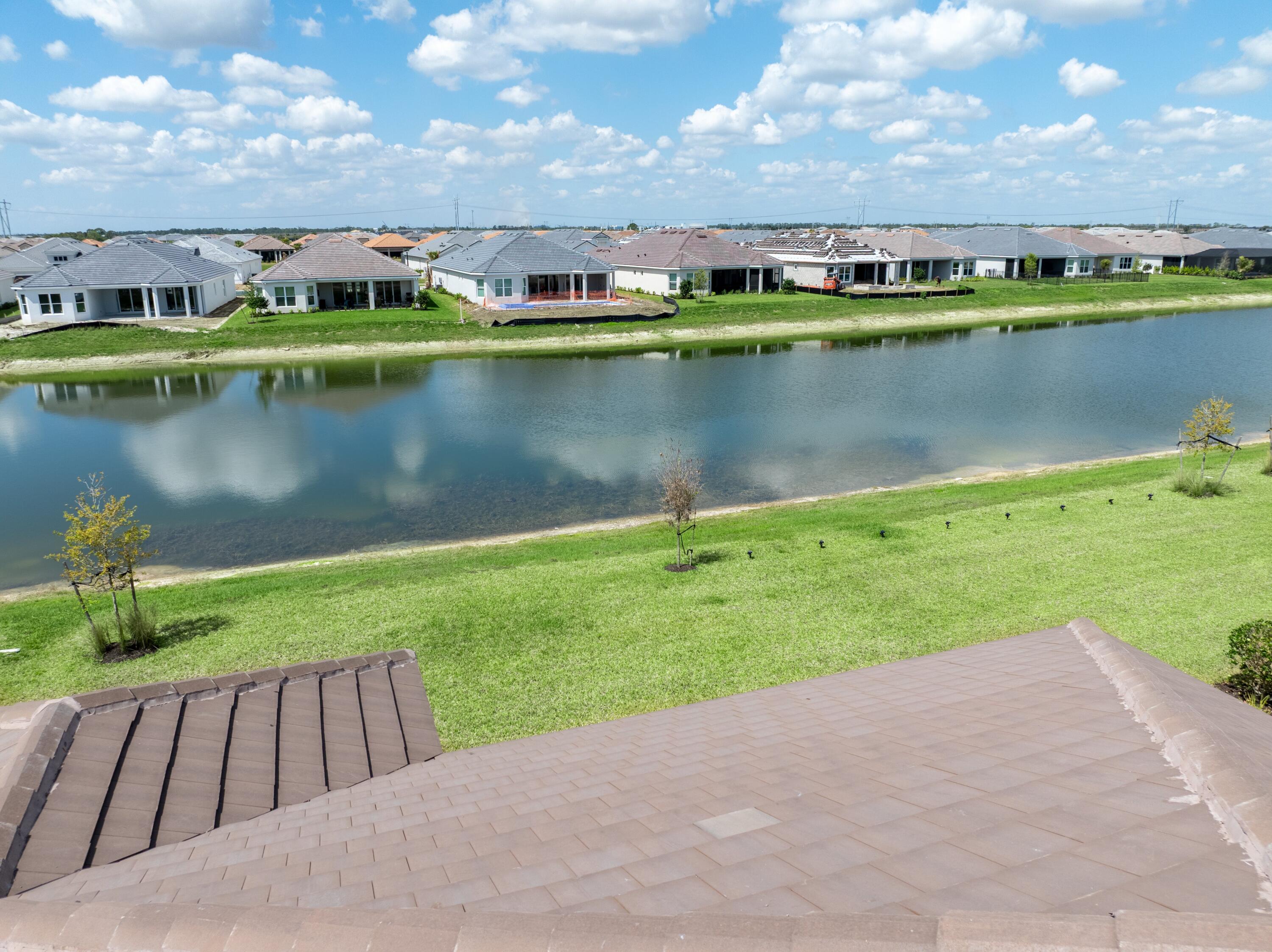 9876 Santini Road Port St. Lucie, FL 34987 - Photo 26 of 45 an aerial view of a house with a yard and lake view
