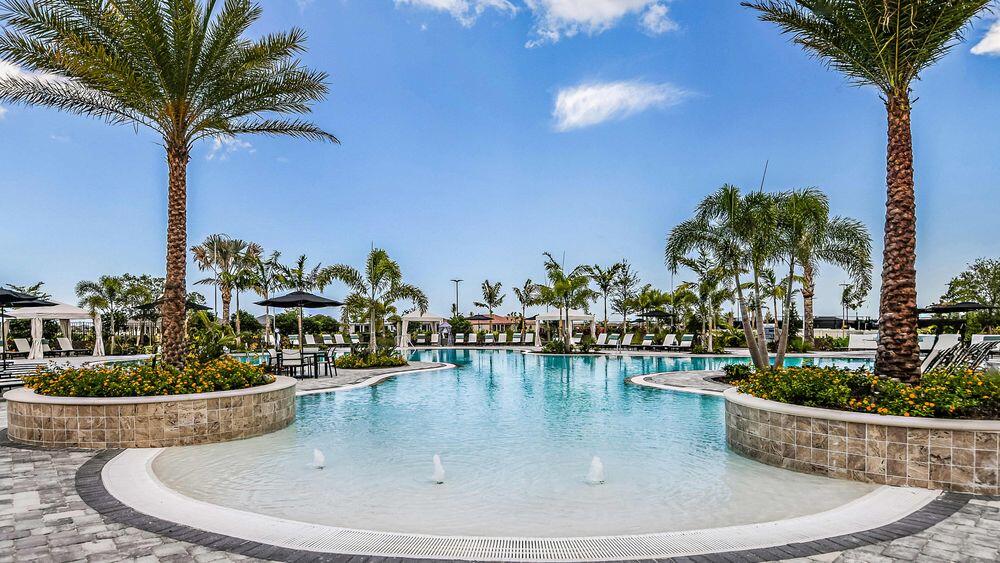 9876 Santini Road Port St. Lucie, FL 34987 - Photo 39 of 45 a view of a swimming pool with a lawn chairs under an umbrella
