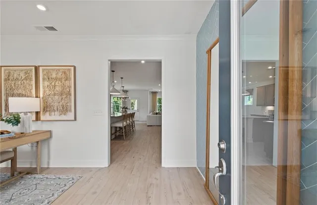 a view of a livingroom and a dining room with wooden floor windows