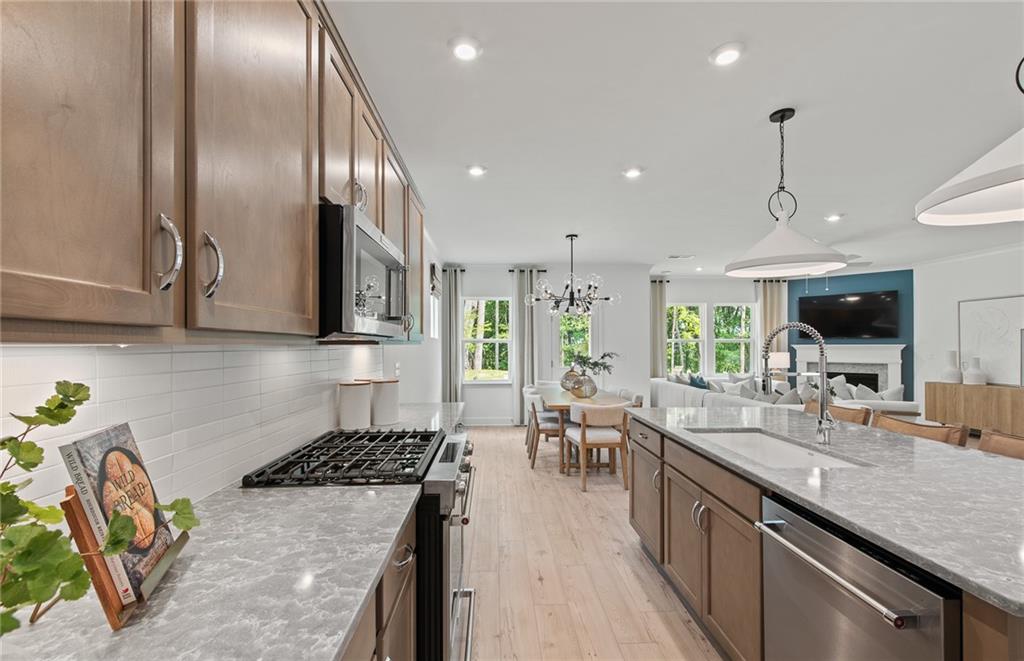 810 Tupelo Way Villa Rica, GA 30180 - Photo 15 of 41 a kitchen with stainless steel appliances granite countertop a stove a sink a oven a dining table and chairs with wooden floor