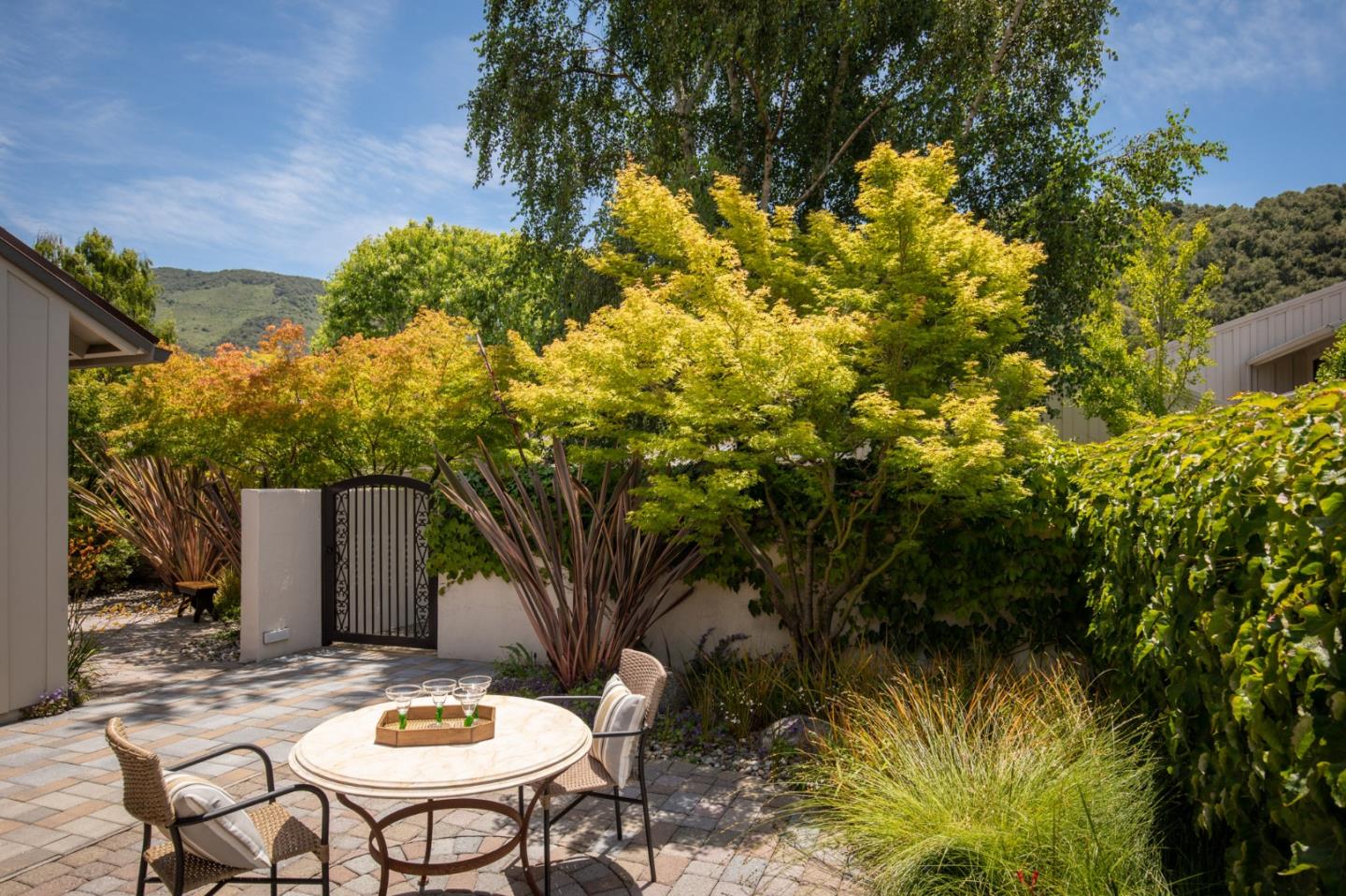 9546 Maple Court Carmel, CA 93923 - Photo 12 of 20 a backyard of a house with table and chairs under an umbrella