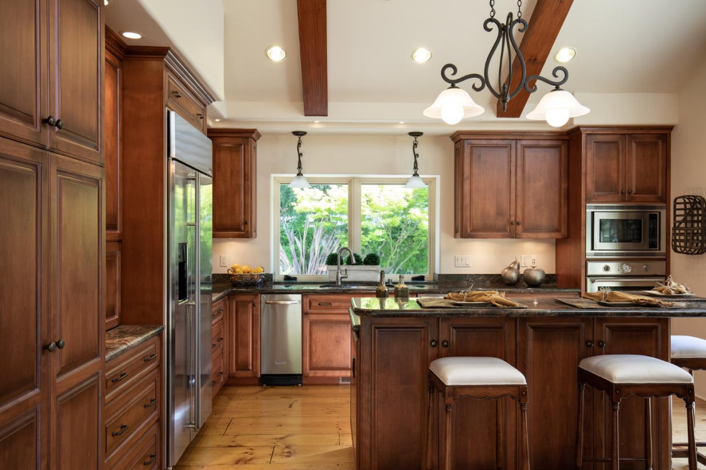 9546 Maple Court Carmel, CA 93923 - Photo 3 of 20 a kitchen with kitchen island granite countertop a sink a counter top space appliances and cabinets