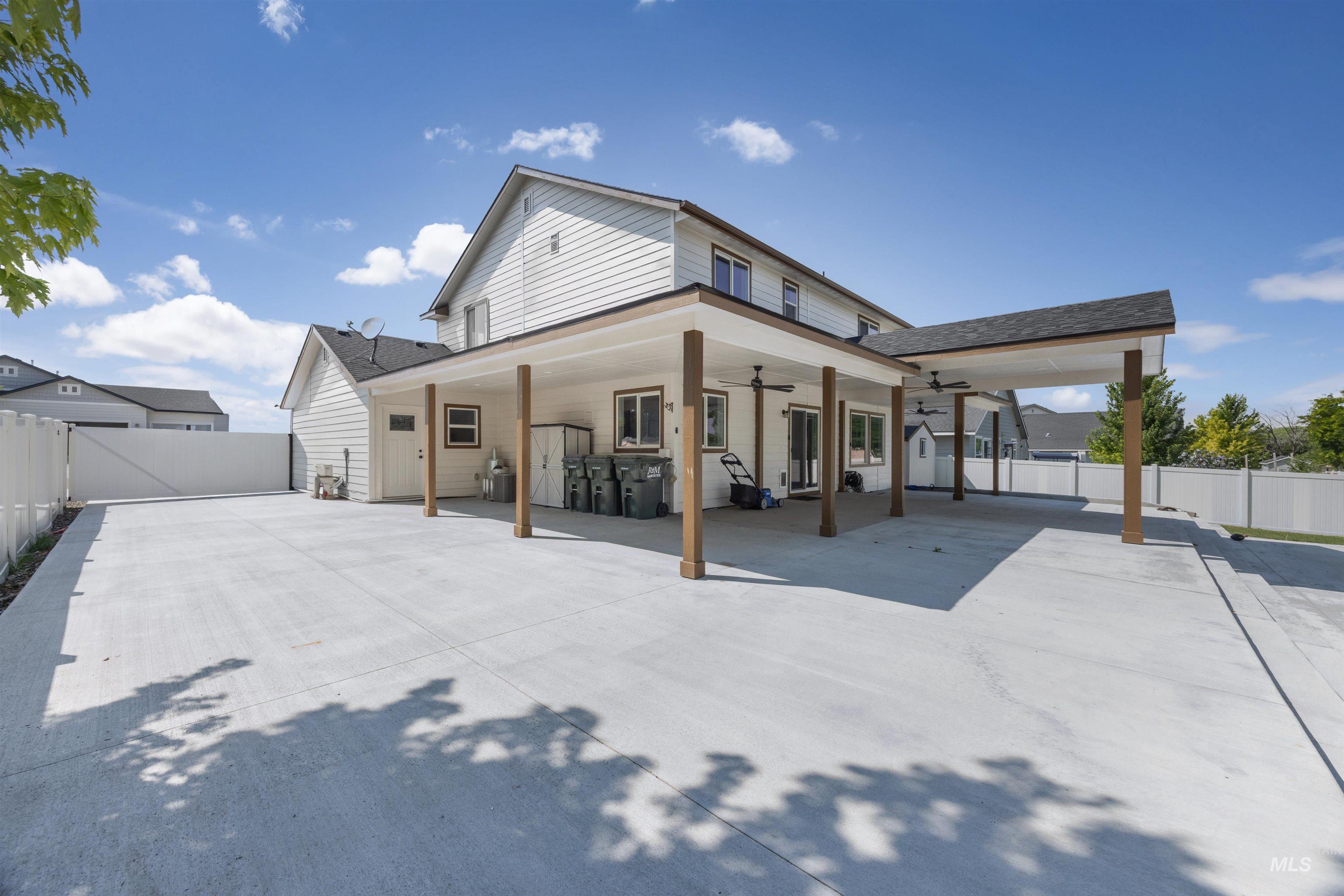 300 South Rocker Avenue Kuna, ID 83634 - Photo 39 of 49 Expansive concrete patio and driveway featuring a covered outdoor living area with wood support columns and ceiling fans