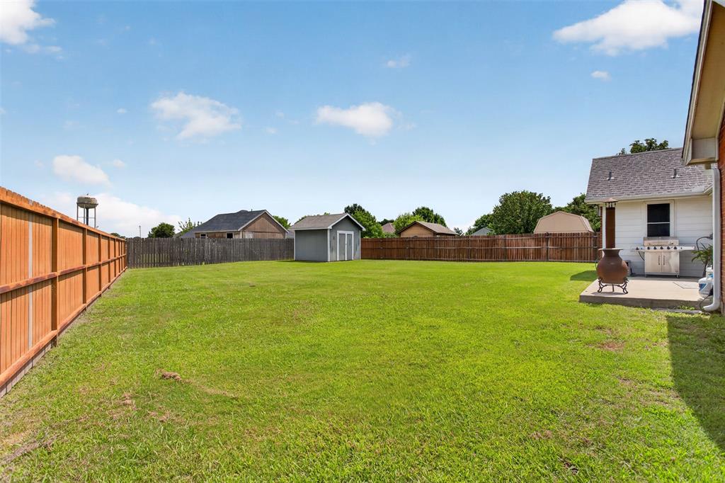 100 Radecke Road Krum, TX 76249 - Photo 28 of 29 Expansive green lawn with a wood privacy fence