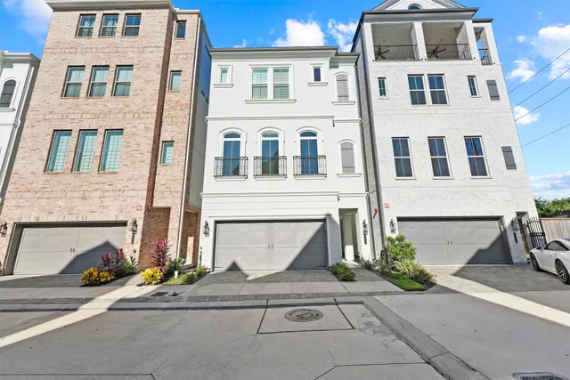 a front view of a building with a yard and parking space