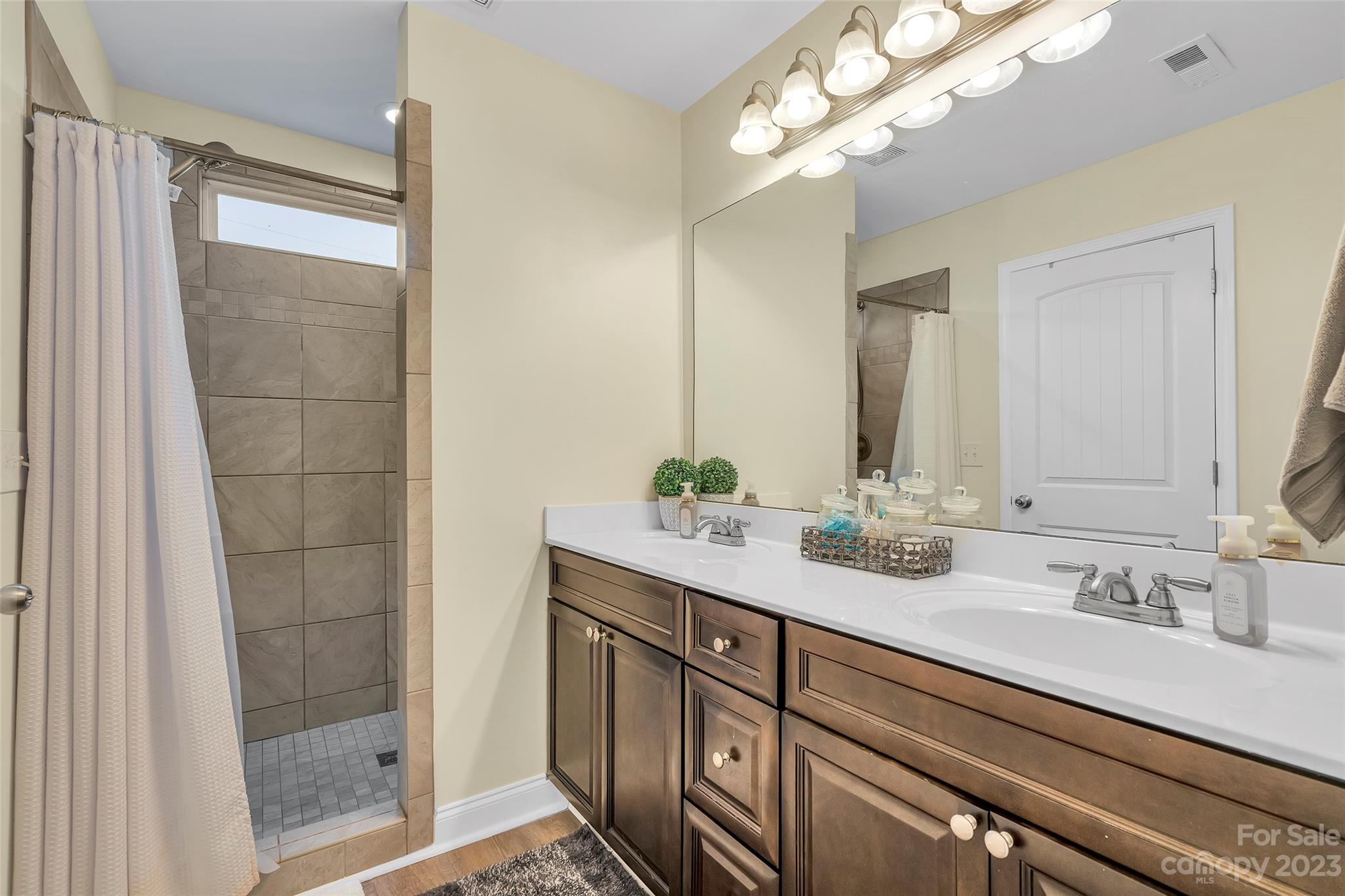 871 West Keepsake Lane Inman, SC 29349 - Photo 15 of 26 a bathroom with a double vanity sink a large mirror and shower