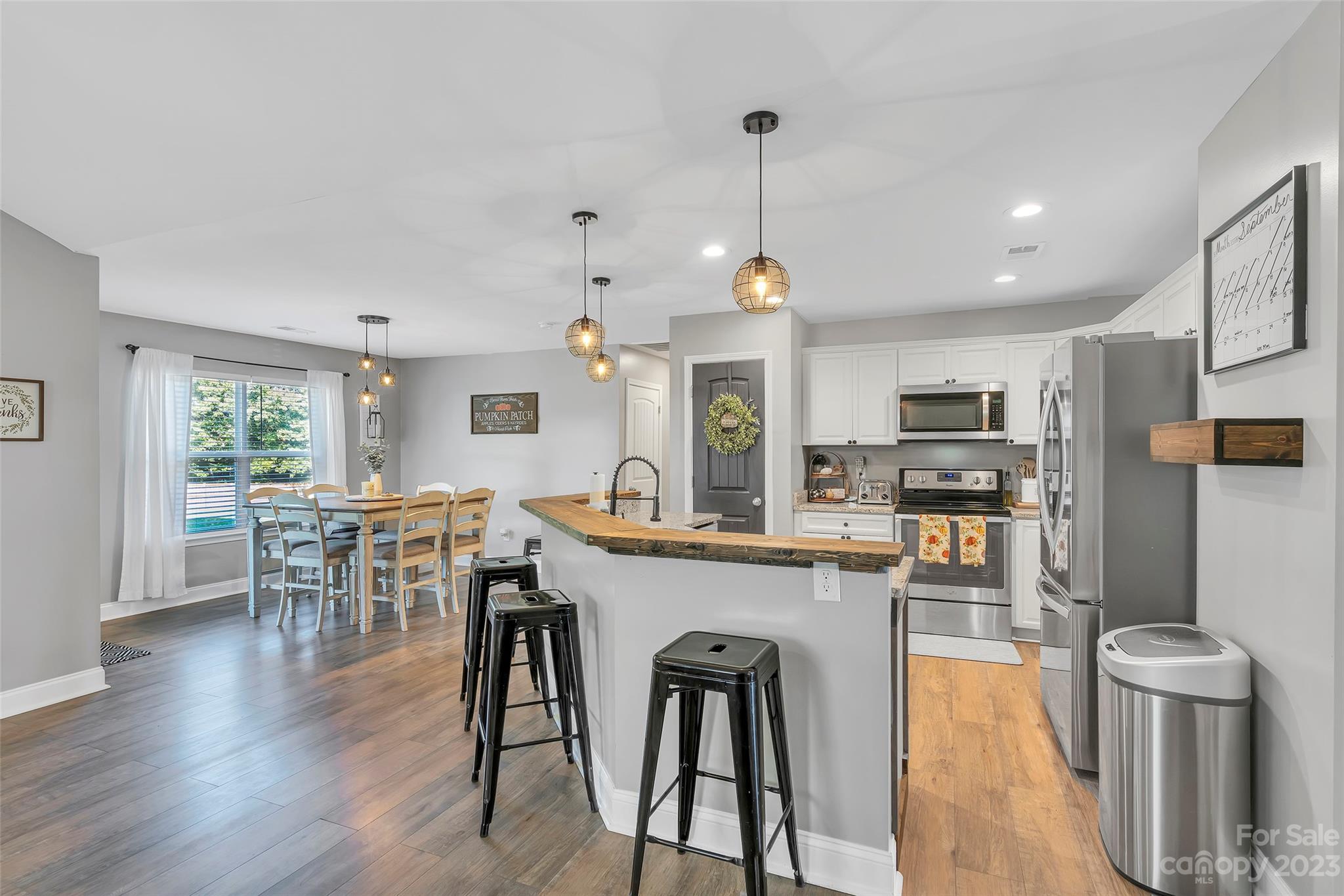 871 West Keepsake Lane Inman, SC 29349 - Photo 7 of 26 a kitchen with stainless steel appliances a dining table chairs stove and wooden floor