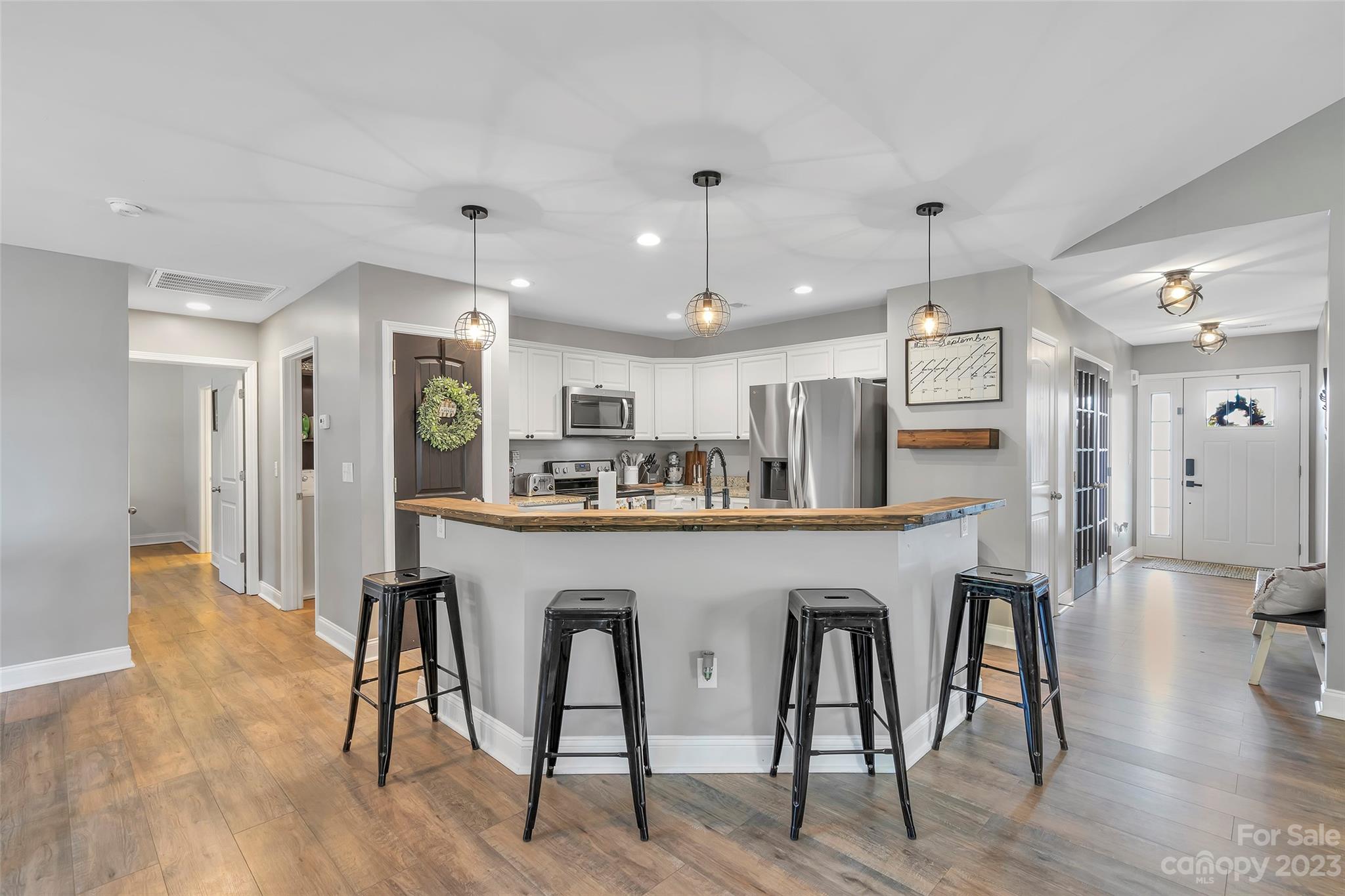 871 West Keepsake Lane Inman, SC 29349 - Photo 8 of 26 a kitchen with stainless steel appliances a dining table chairs refrigerator and microwave