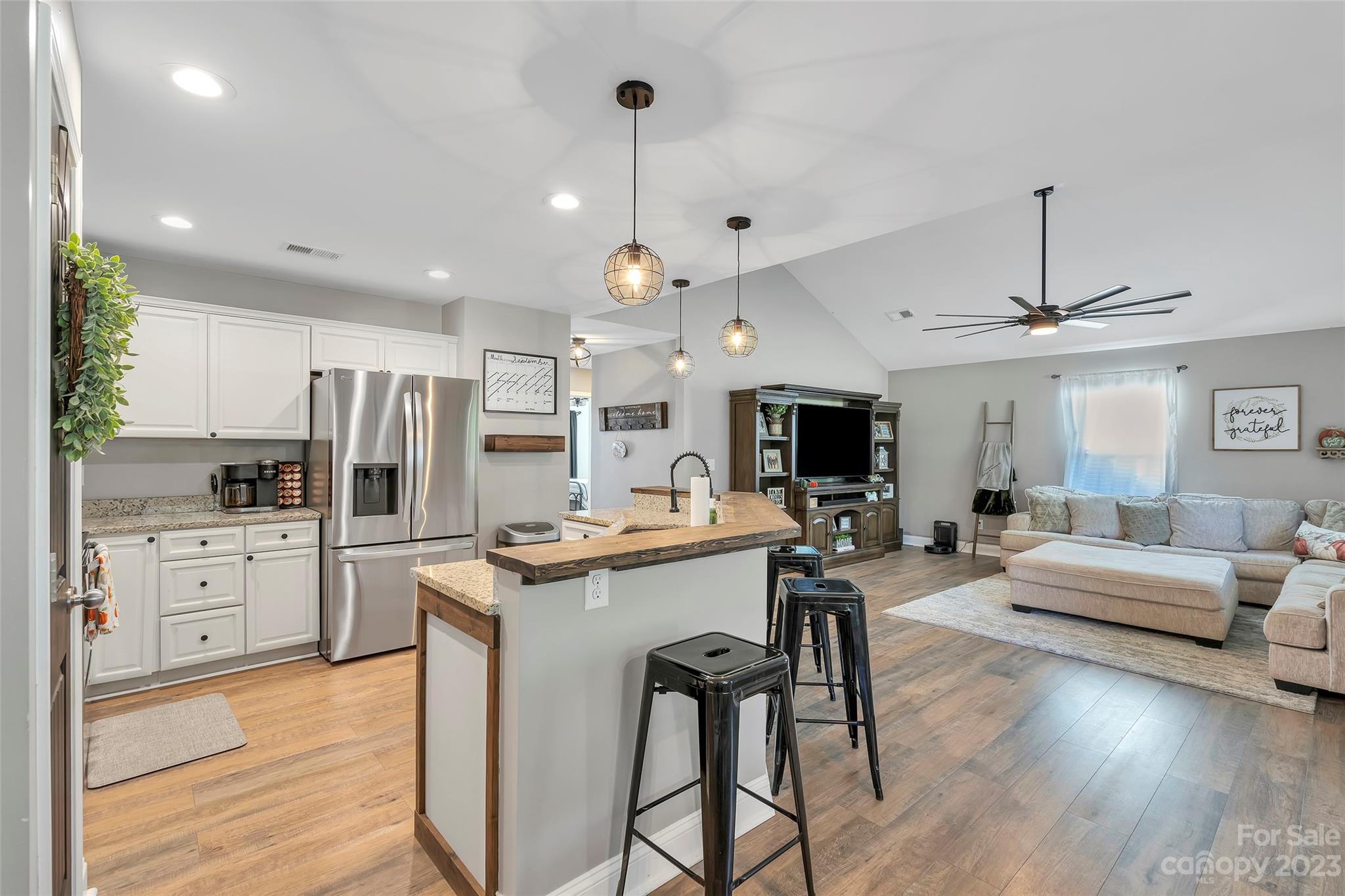 871 West Keepsake Lane Inman, SC 29349 - Photo 9 of 26 a kitchen with stainless steel appliances kitchen island granite countertop a stove a sink a refrigerator and white cabinets with wooden floor